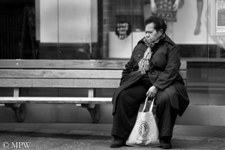 Black and white street scene, woman waiting for the bus on Queen St, Auckland